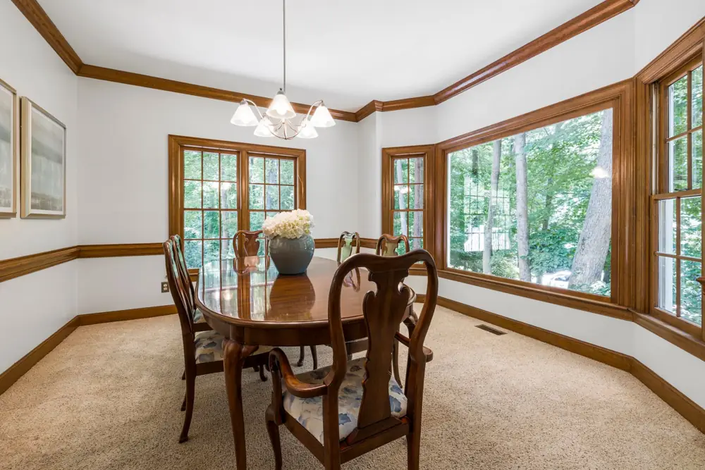 Round dining table and chairs by a bay window